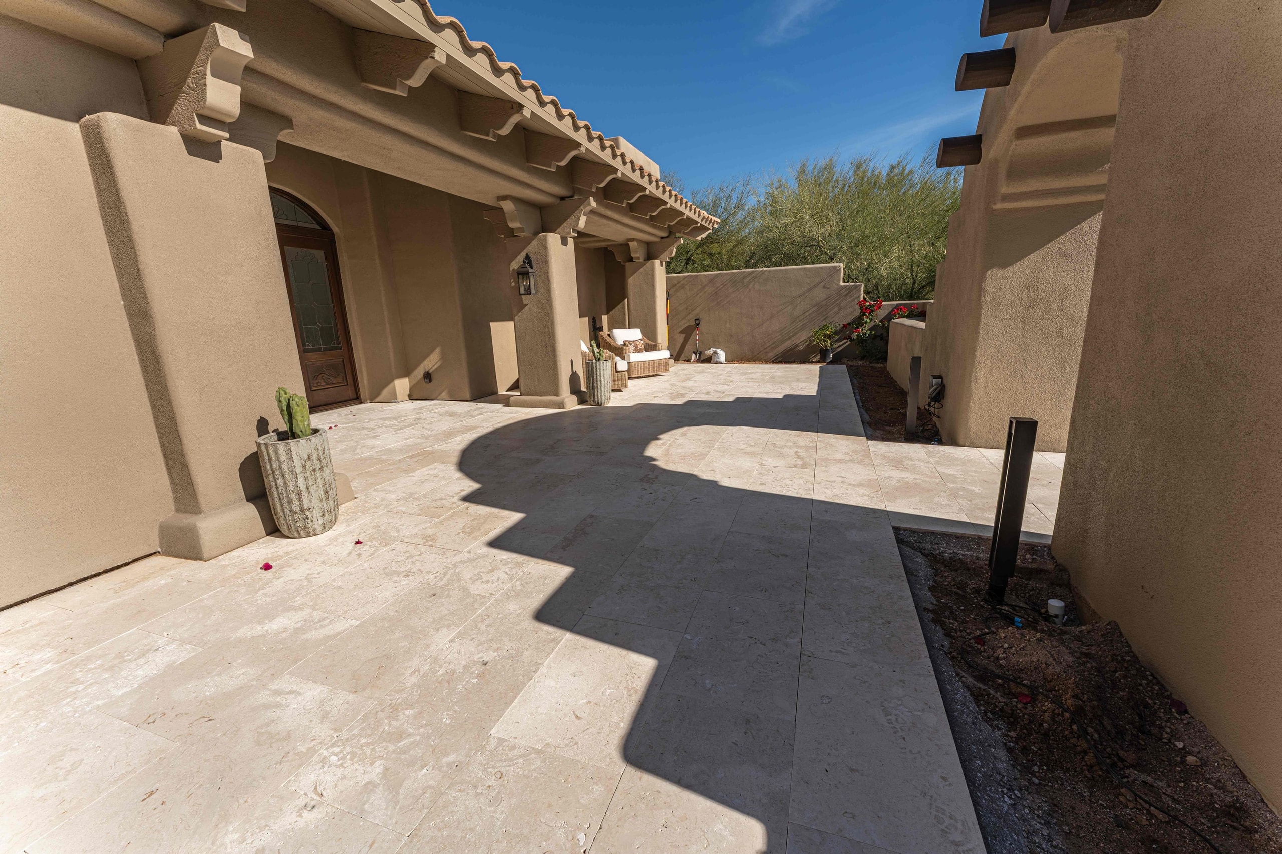 Travertine courtyard patio between stucco walls with clean, tight joints